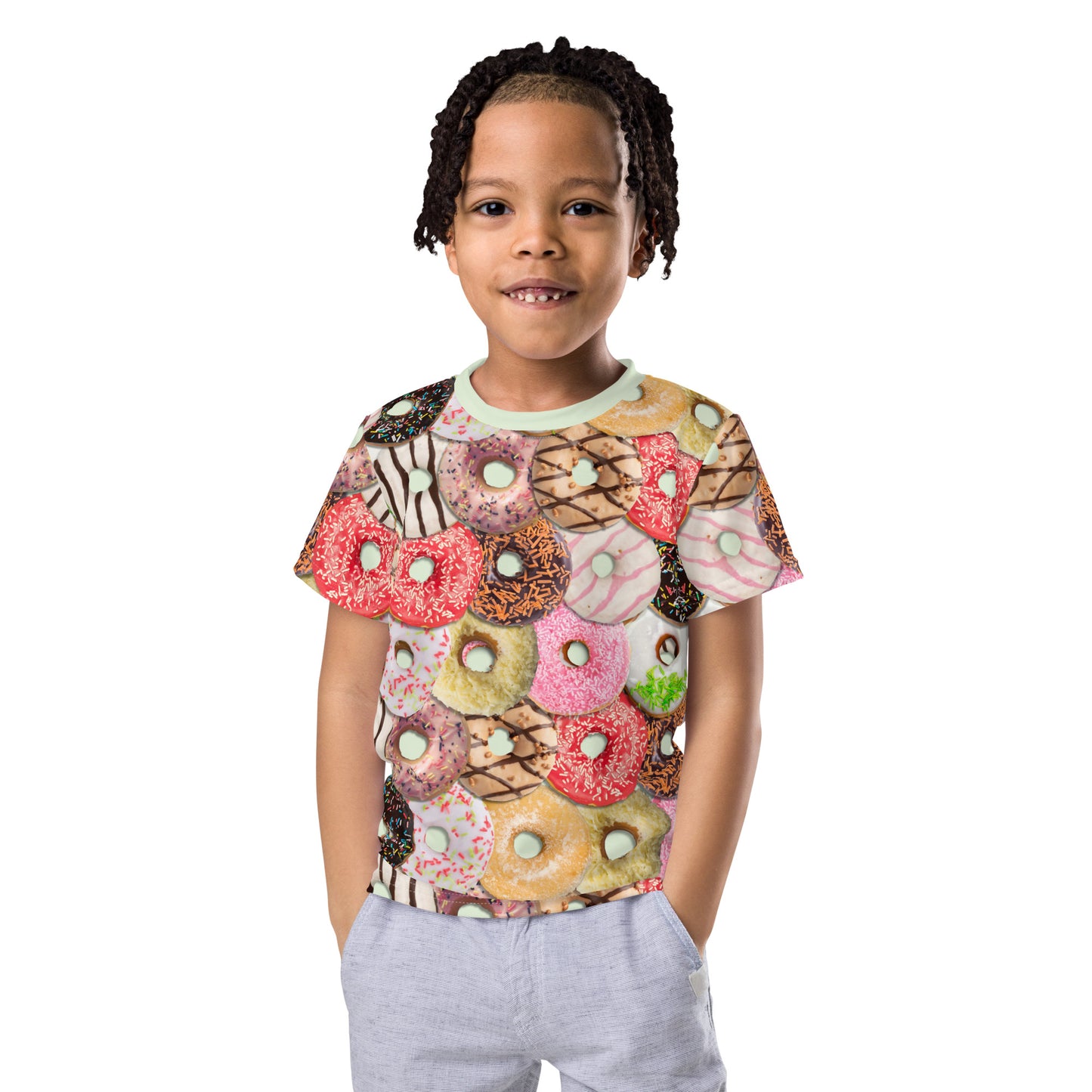 Little boy wearing a colourful iced doughnuts all over print T-shirt, facing forwards.