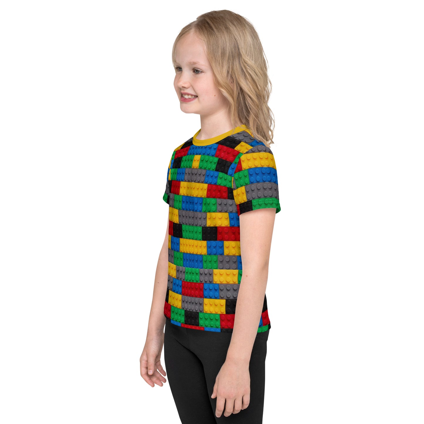 Little girl wearing a colourful building blocks all over print kid's T-shirt. left side view