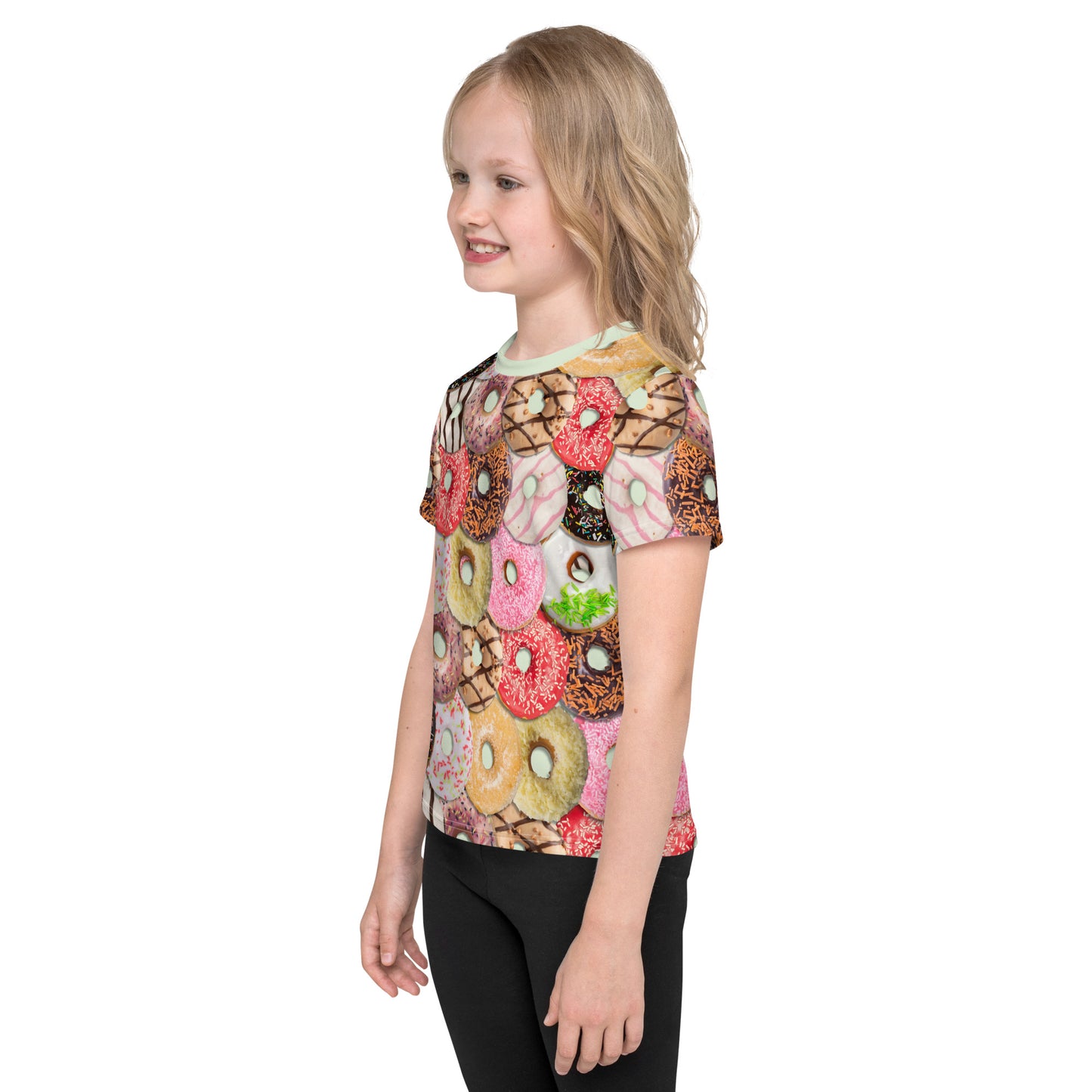 Little girl wearing a colourful iced doughnuts all over print T-shirt, left side.