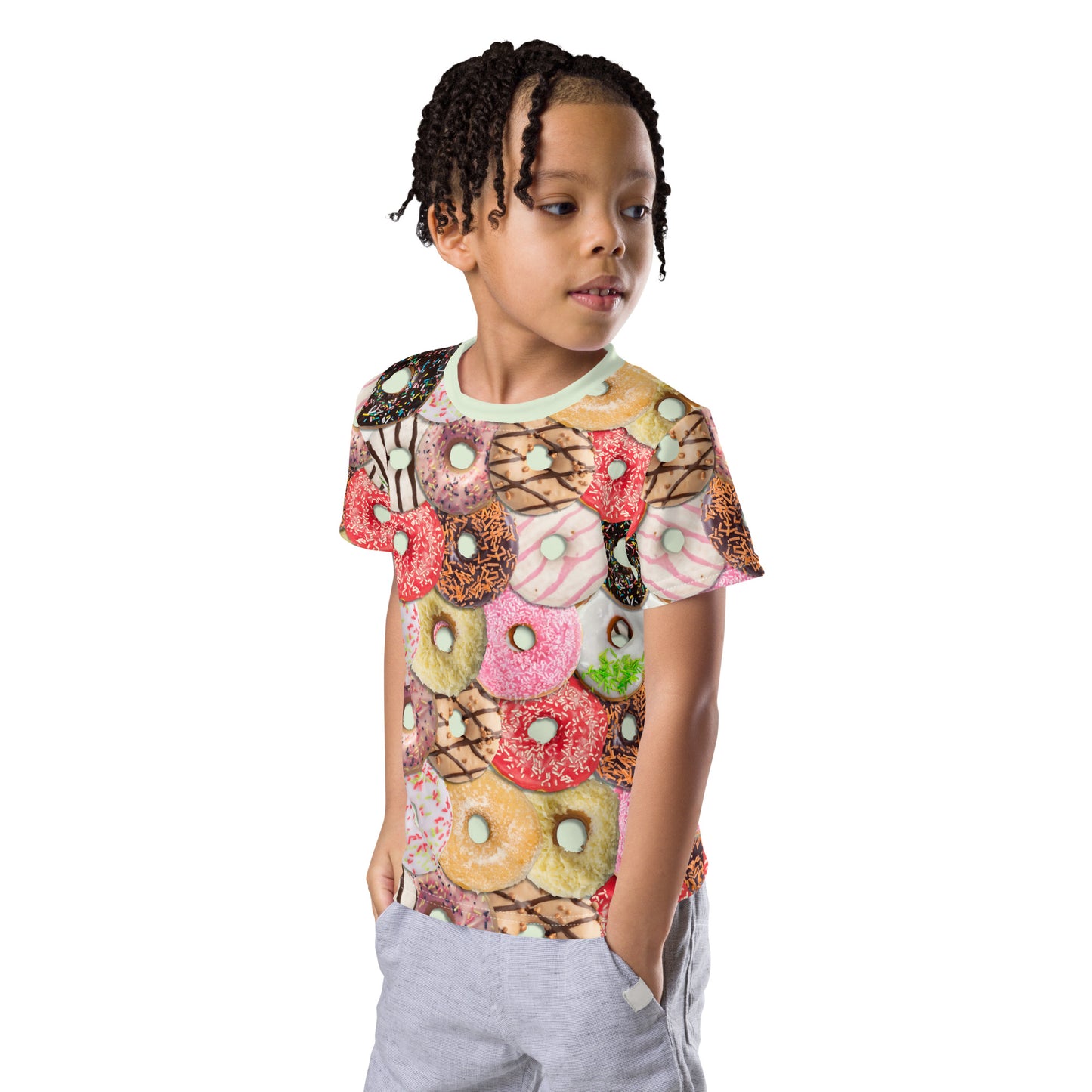 Little boy wearing a colourful iced doughnuts all over print T-shirt, front left side.