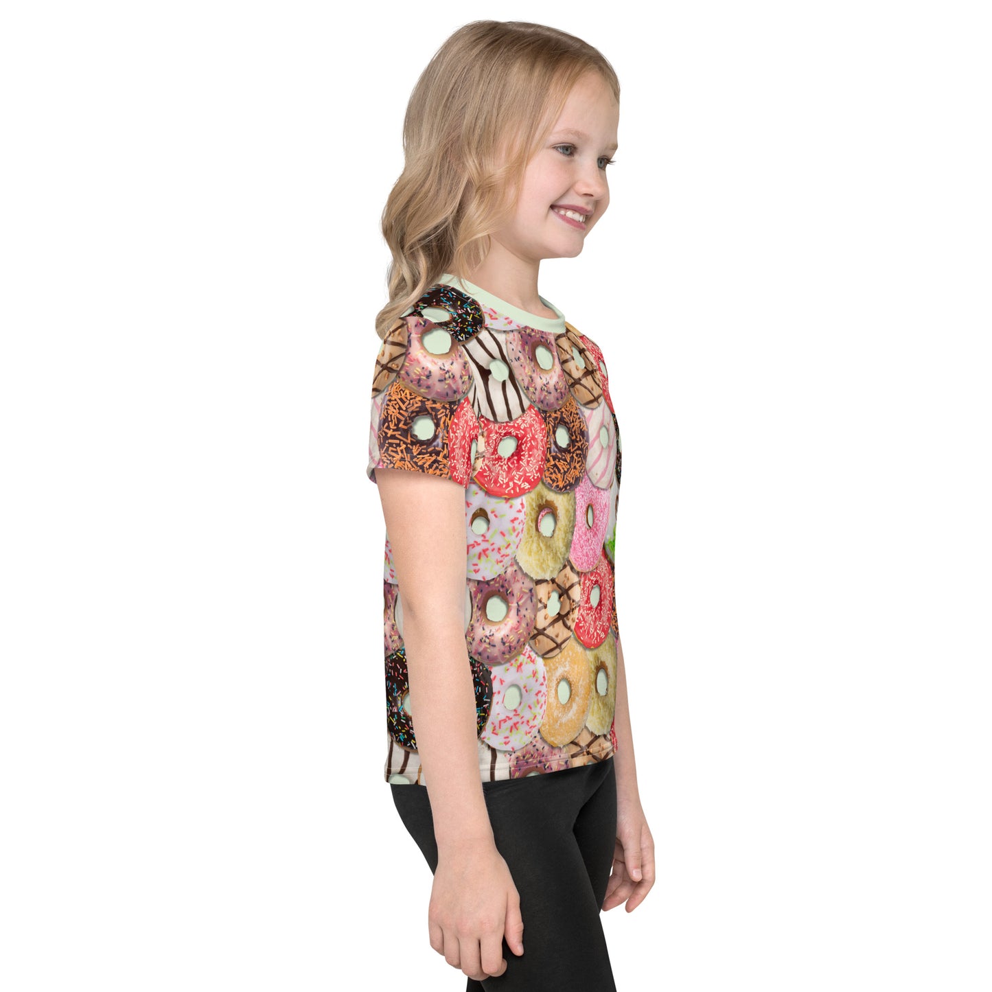 Little girl wearing a colourful iced doughnuts all over print T-shirt, right side.