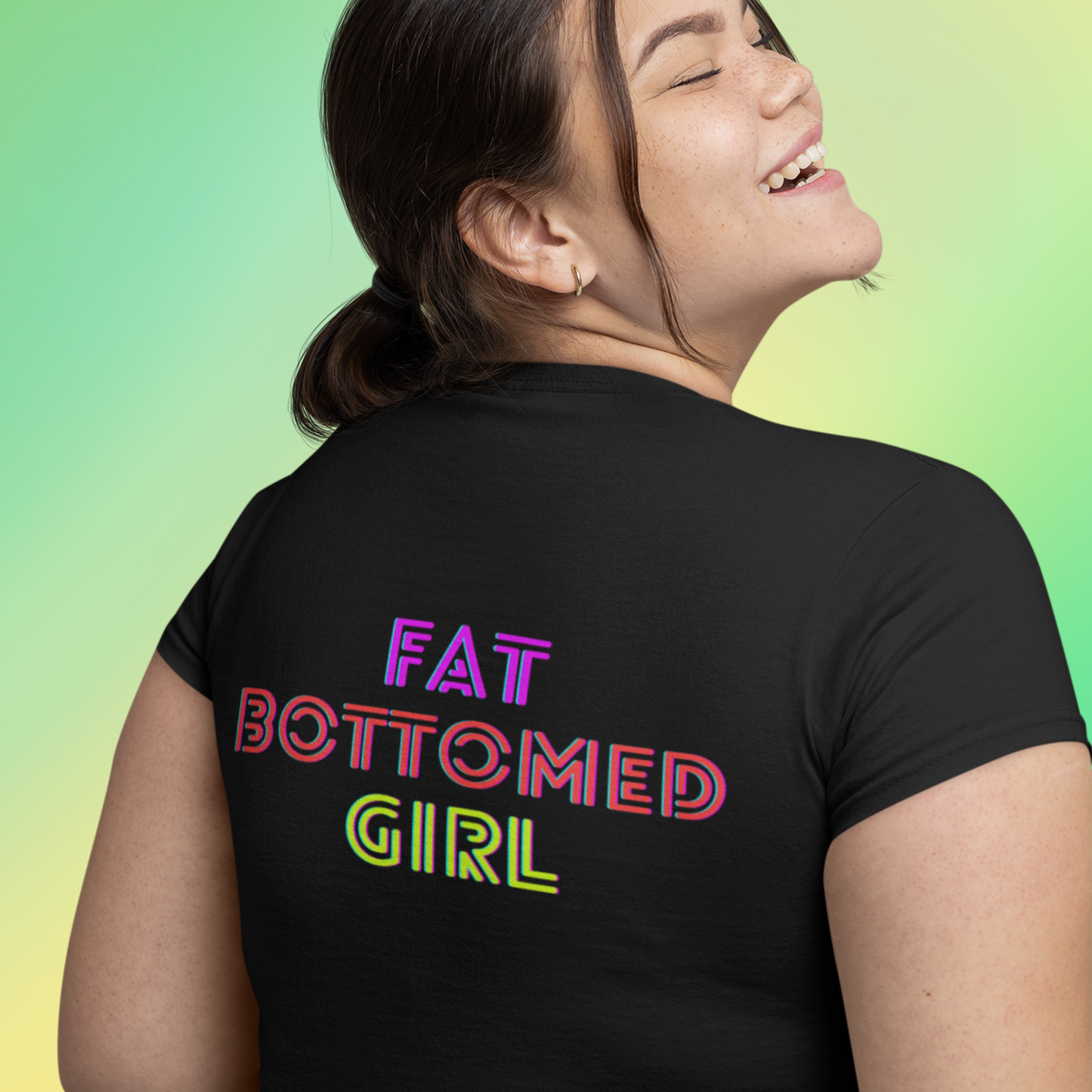 Happy plus sized female model wearing a Black T-shirt with Fat Bottomed Girl on the front and the back of the shirt.