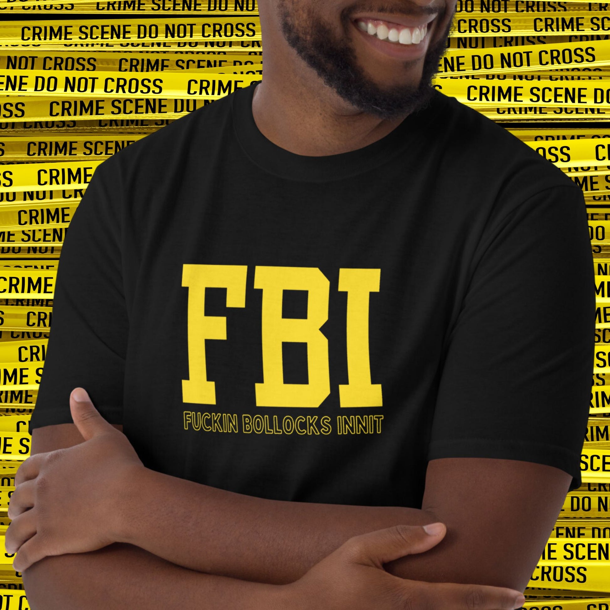 Laughing man standing in front of Police Crime Scene Tape wearing a Black T-shirt that reads in yellow text 'FBI', then in smaller print 'Fuckin Bollocks Innit'.