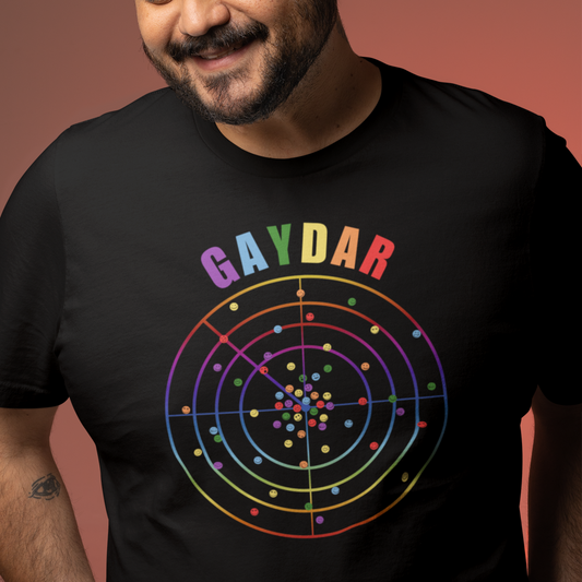 Happy man wearing a Black LGBTQ T-shirt with GAYDAR in pride colours and a graphic of a radar with lots of colourful dots on it with happy faces.
