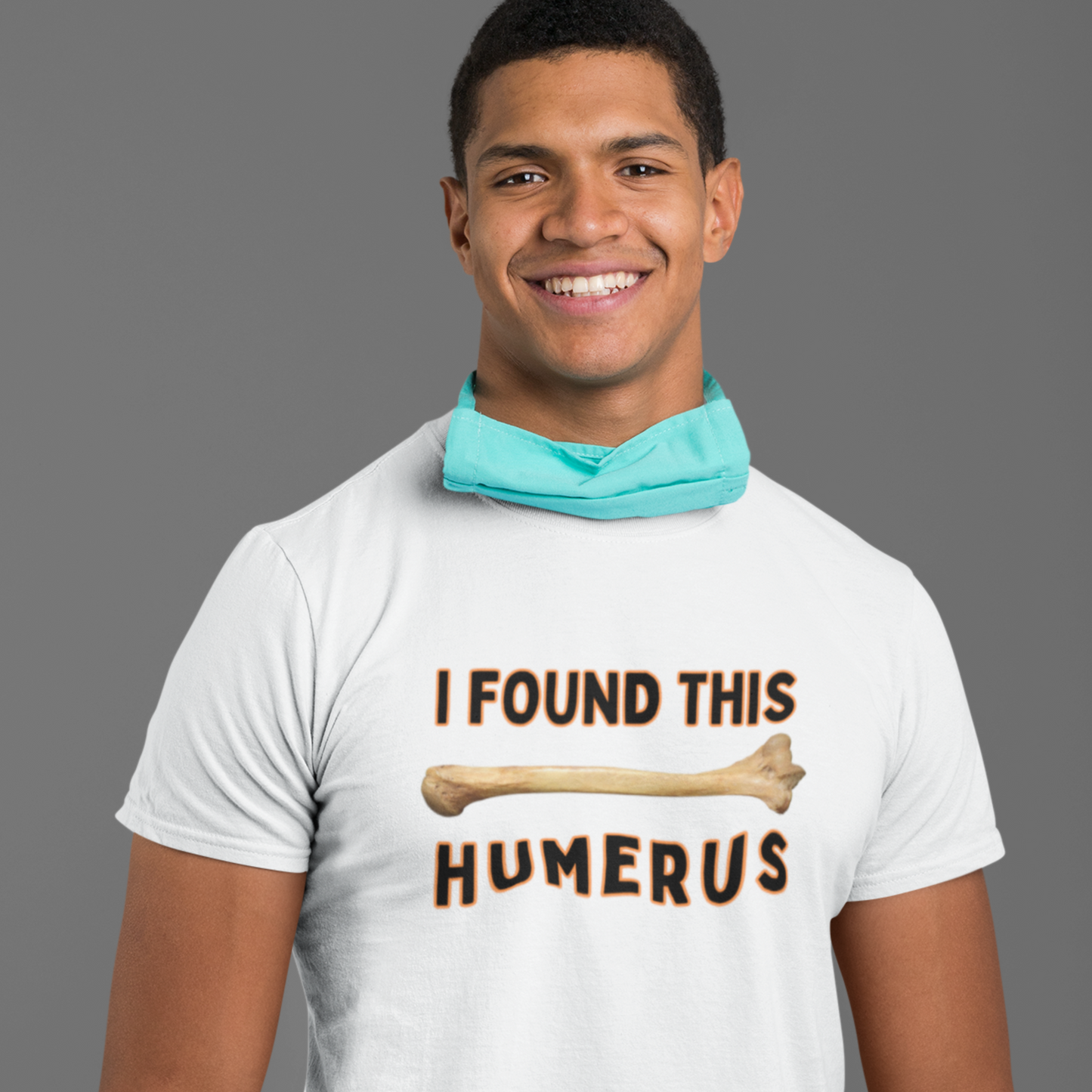 Male nurse wearing a Funny T-shirt that has a arm bone on it and reads 'I found this humerus' in white with black letters