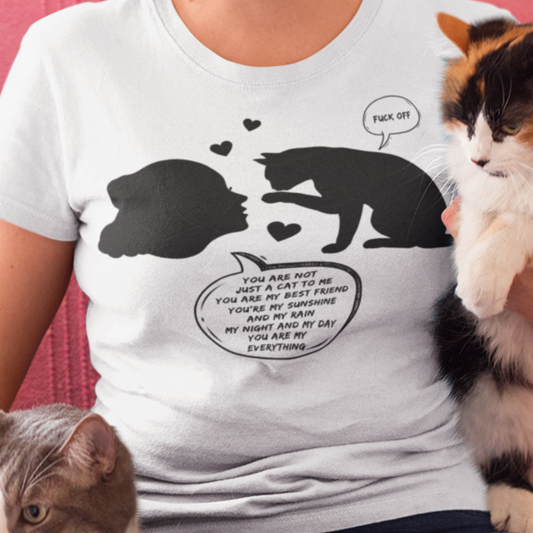 woman cuddling her cats waering a white Rude cat T-shirt with loving woman adoring her cat but the cat is saying Fuck Off