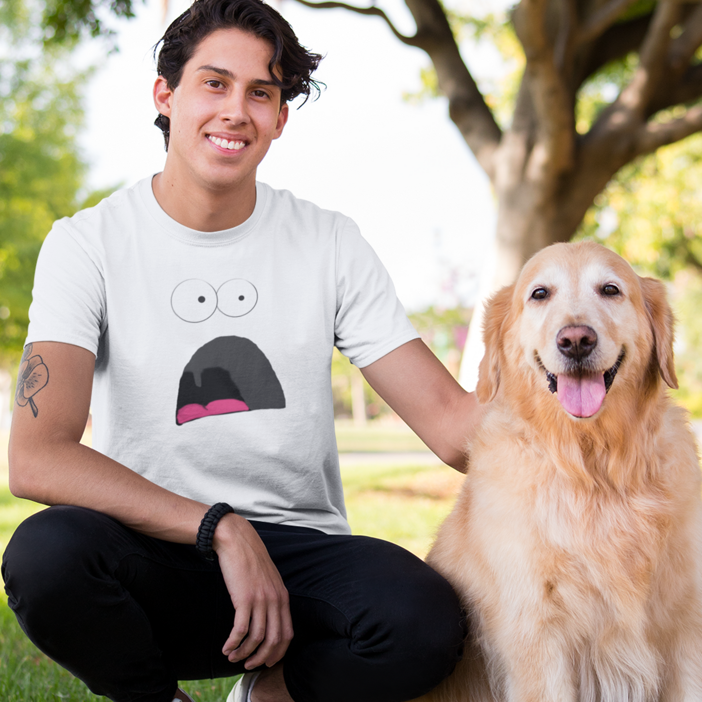 young man and his dog wearing a white tshirt with a shocked face design on