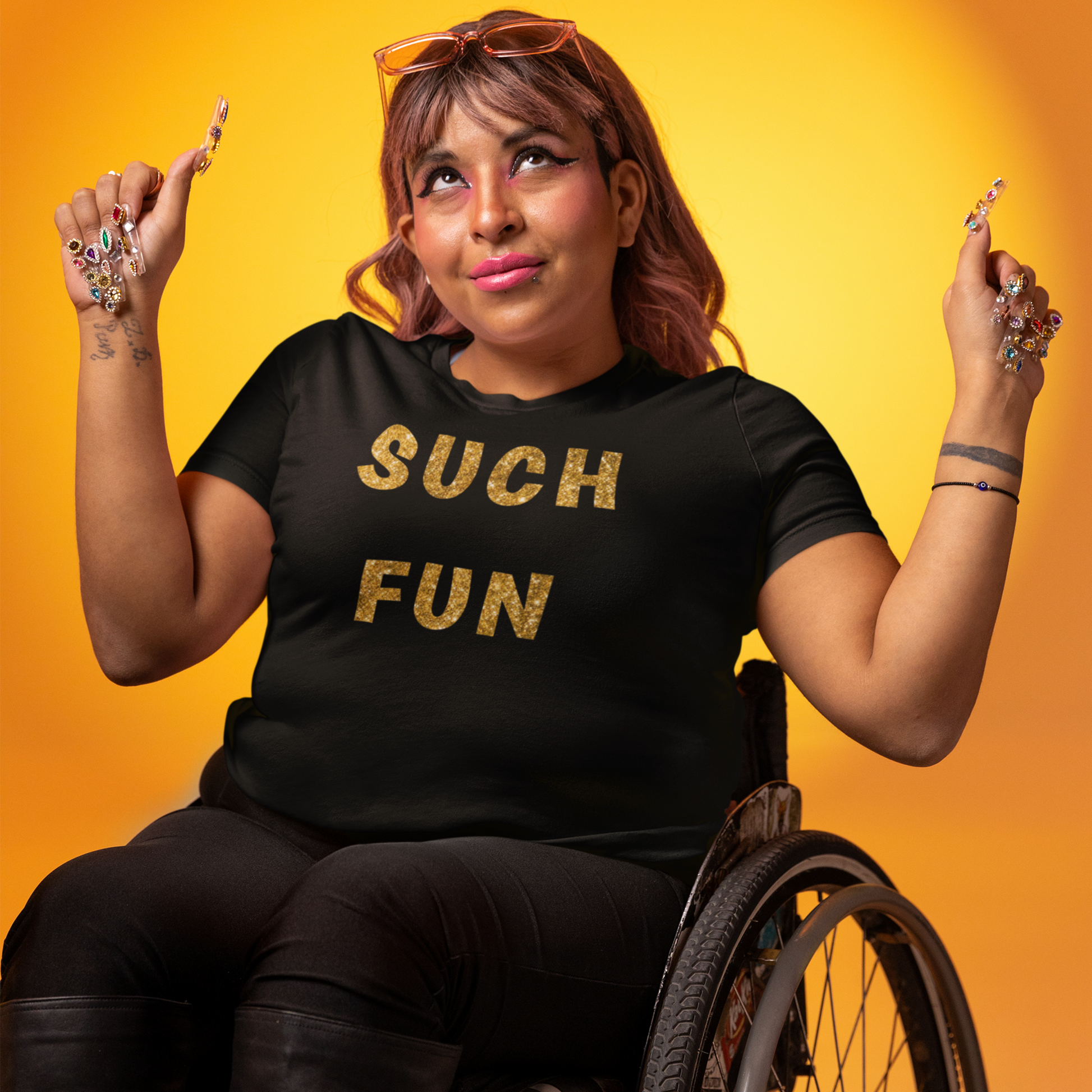 Happy lady in a wheelchair wearing a black Such Fun T-shirt with printed glitter effect gold letters.