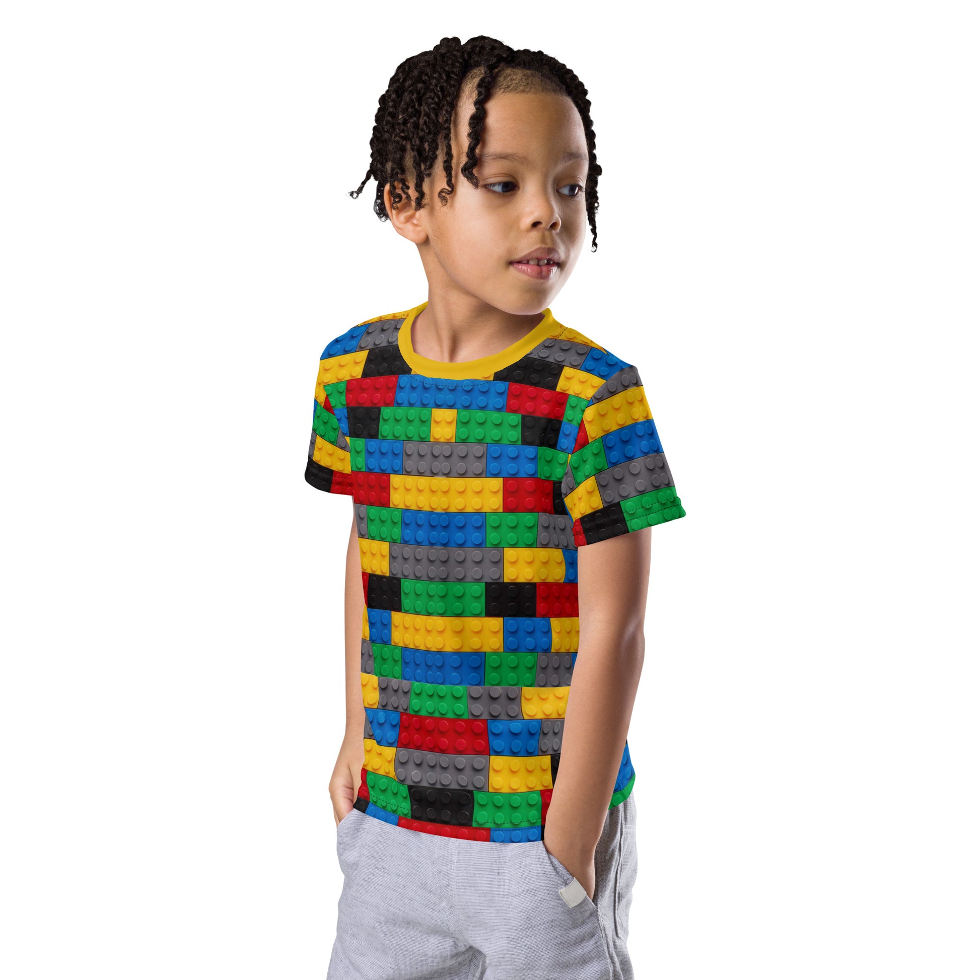 Little boy wearing a colourful building blocks all over print kid's T-shirt. front left view