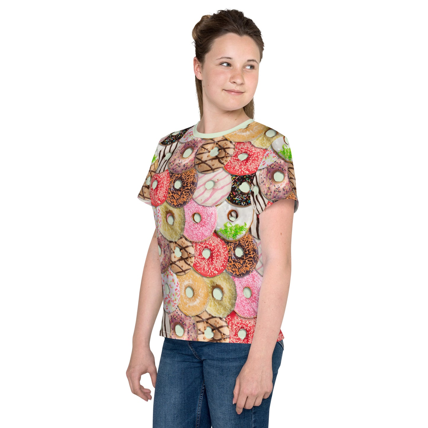 Teenage girl wearing a colourful iced doughnuts all over print T-shirt, front left view.