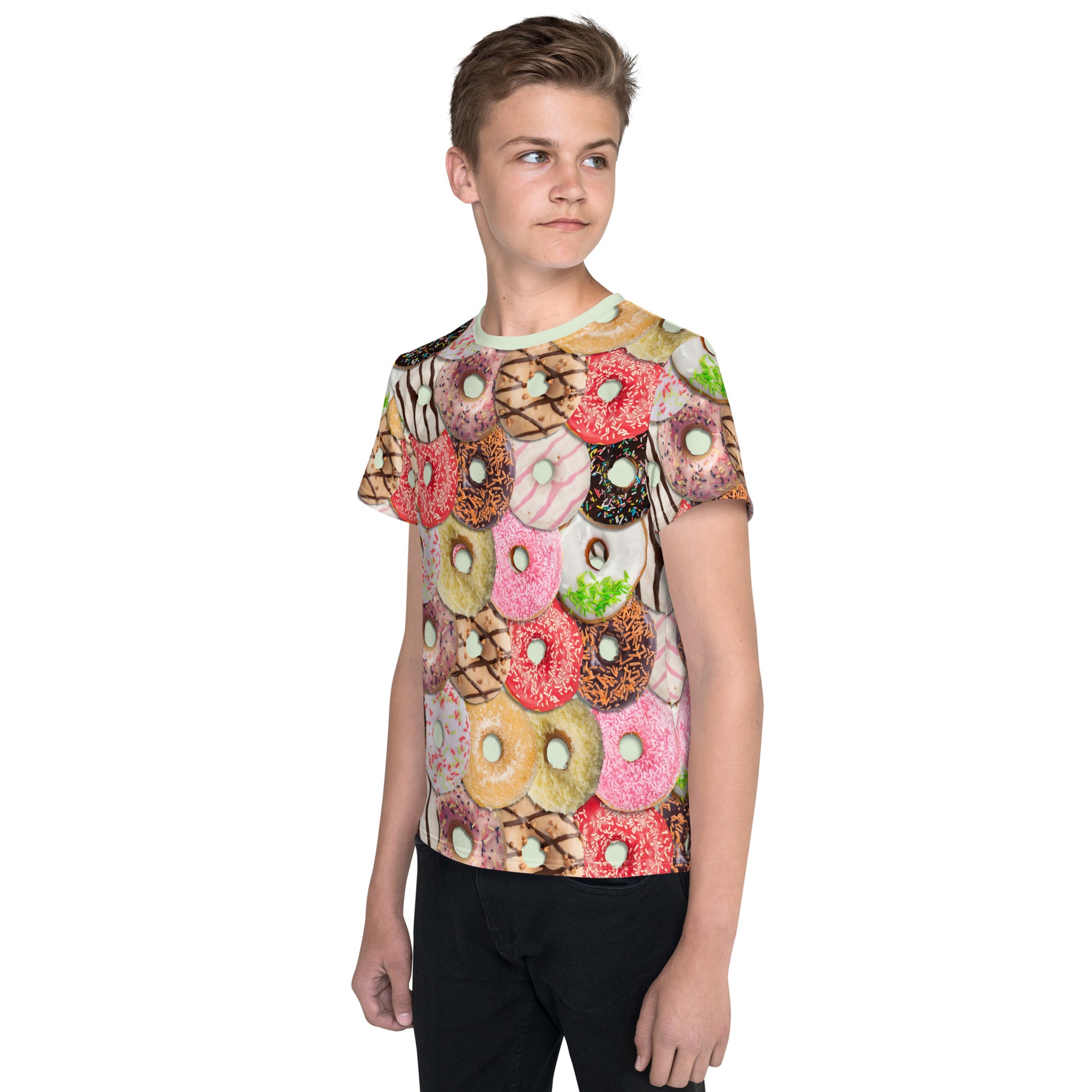 Teenage boy wearing a colourful iced doughnuts all over print T-shirt, front left view.