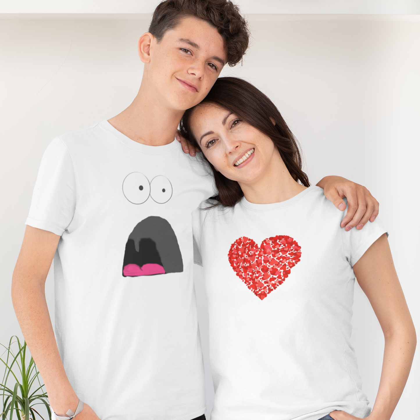 young couple cuddling, the woman wearing a love heart t-shirt and the man wearing a funny shocked scared face cartoon design t-shirt