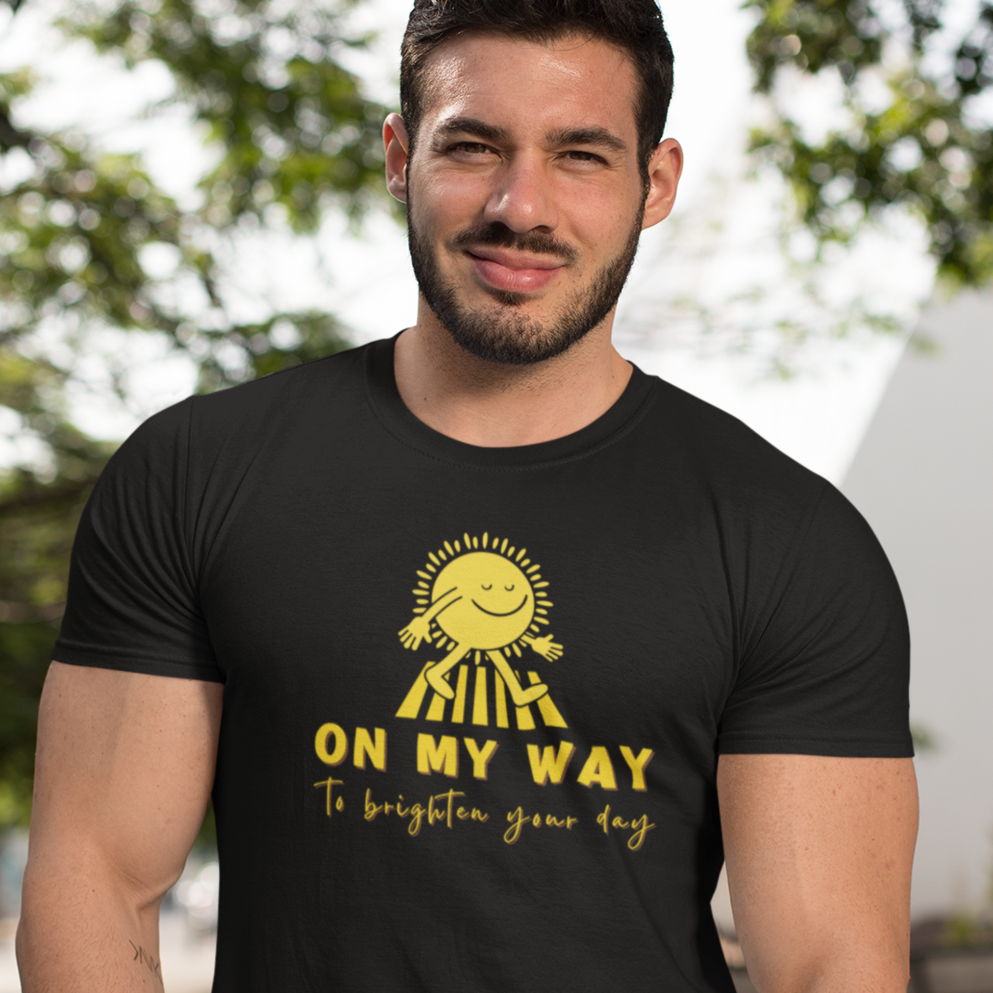 Muscular young happy man wearing a black T shirt with a walking sun that reads On My Way To Brighten Your Day