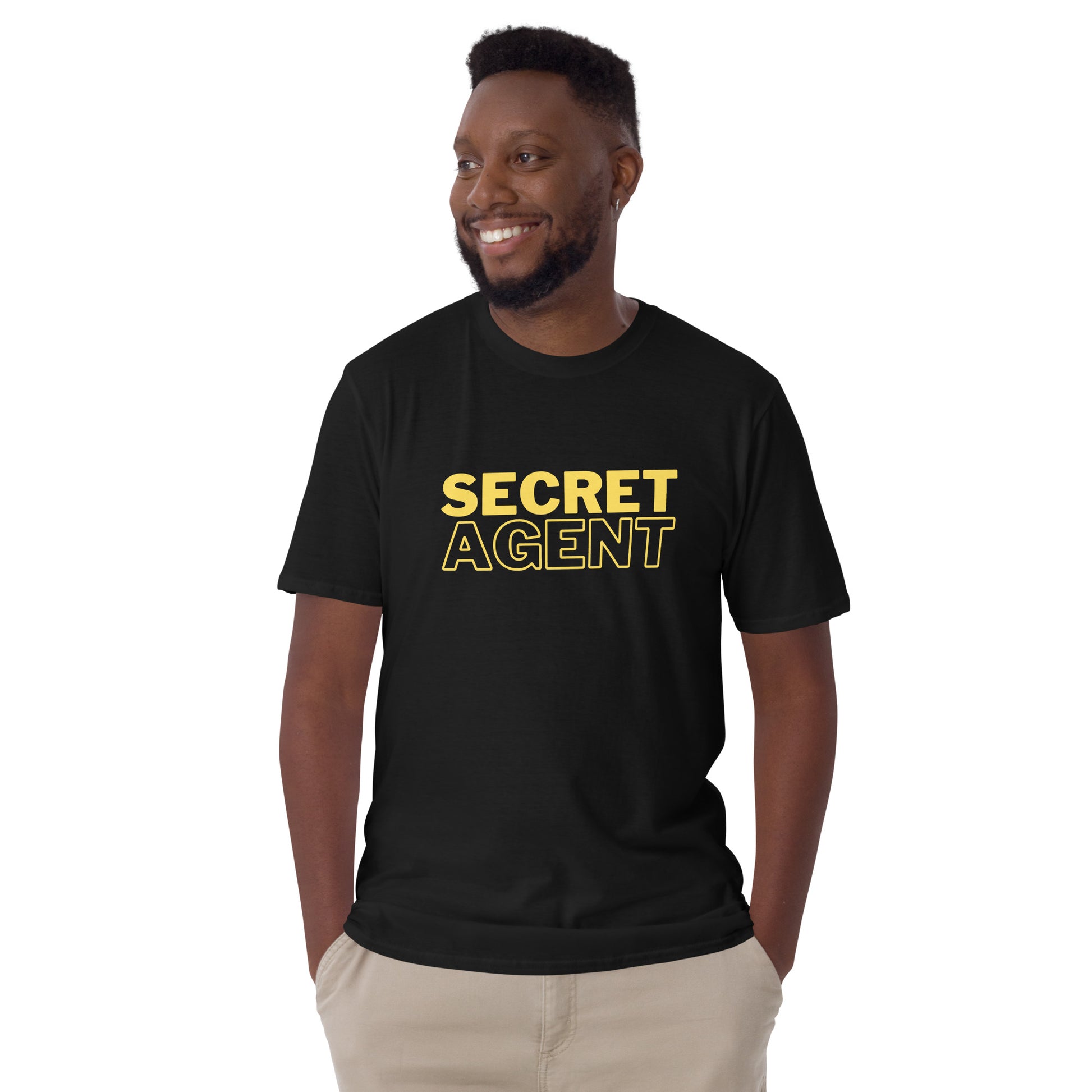 Laughing male model wearing a Black unisex T-shirt that reads SECRET AGENT in yellow text