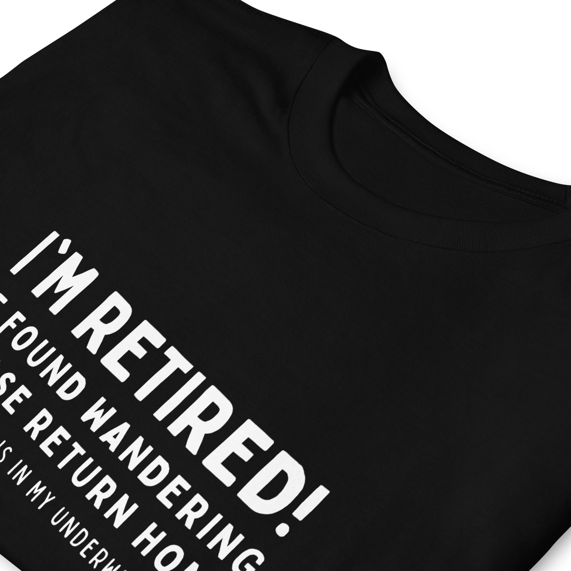 Funny retirement T-shirt that reads 'I'm retired - If found wandering please return home - address is in my underwear'. Folded black T-shirt with white text.