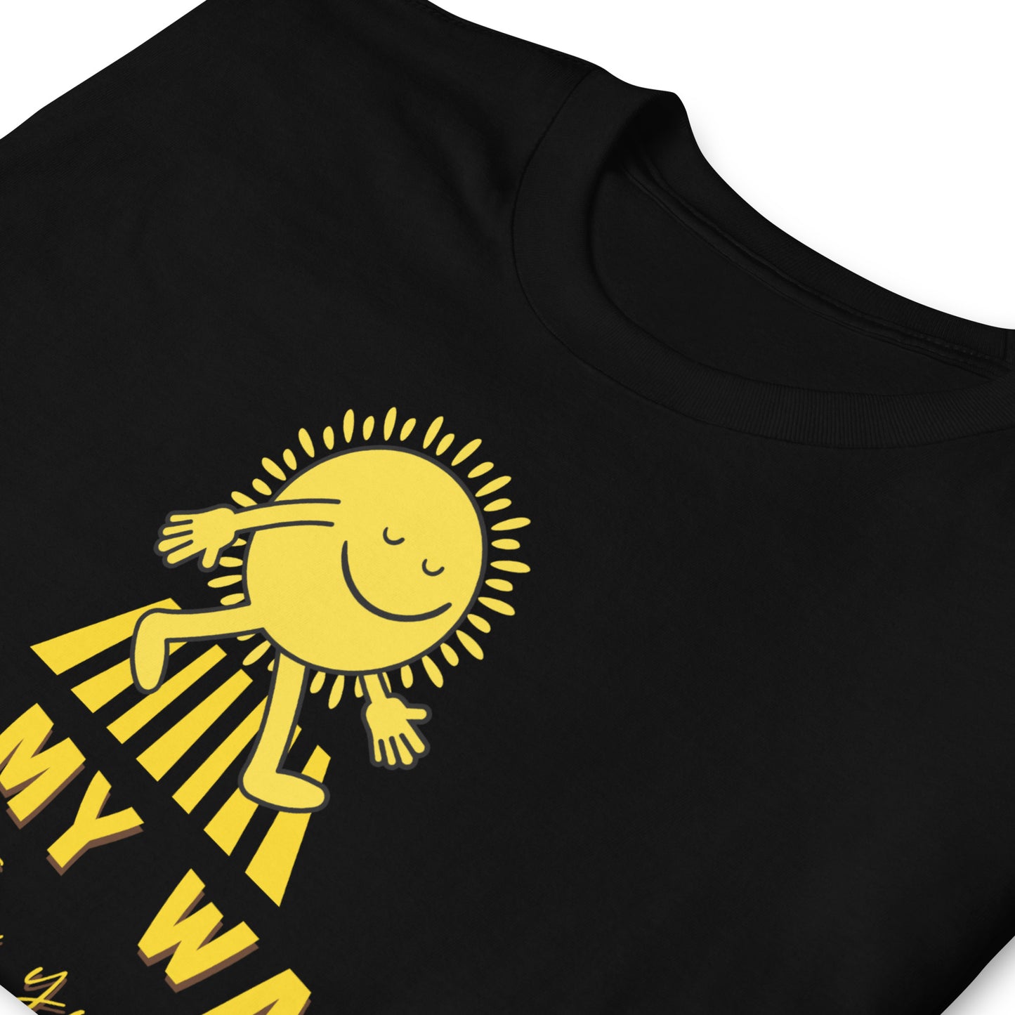 folded black T shirt with a walking sun that reads On My Way To Brighten Your Day