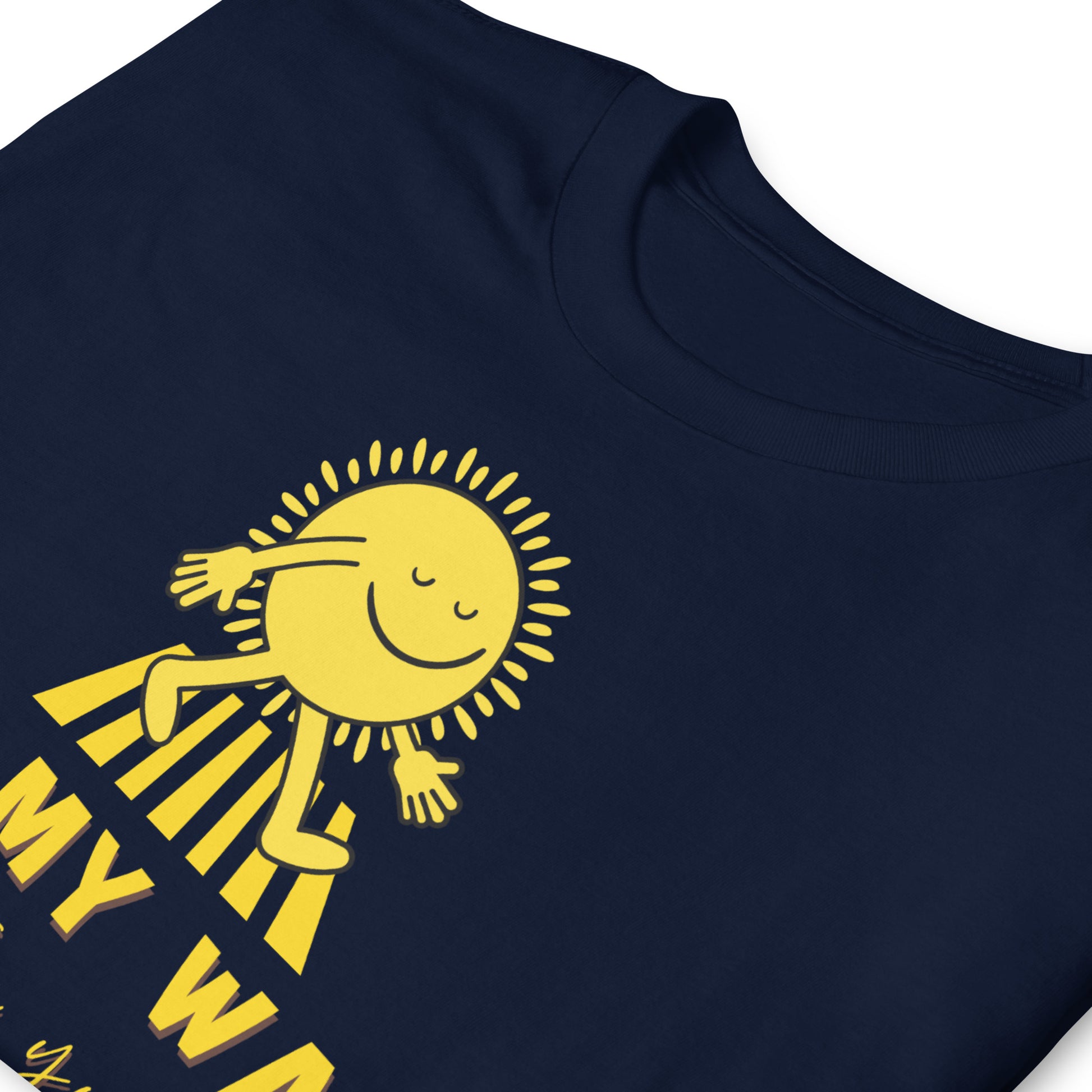 folded navy T shirt with a walking sun that reads On My Way To Brighten Your Day