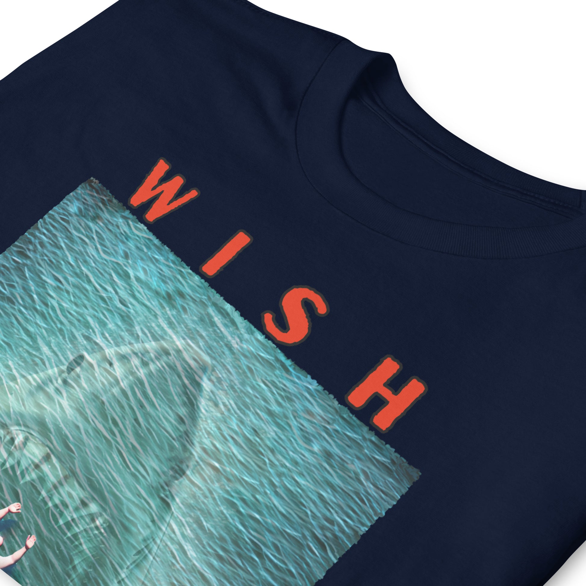 folded, navy, funny T-shirt with an image of a fat guy floating in the sea, with a large shark with its jaws open coming up underneath him, text reads, Wish you were here