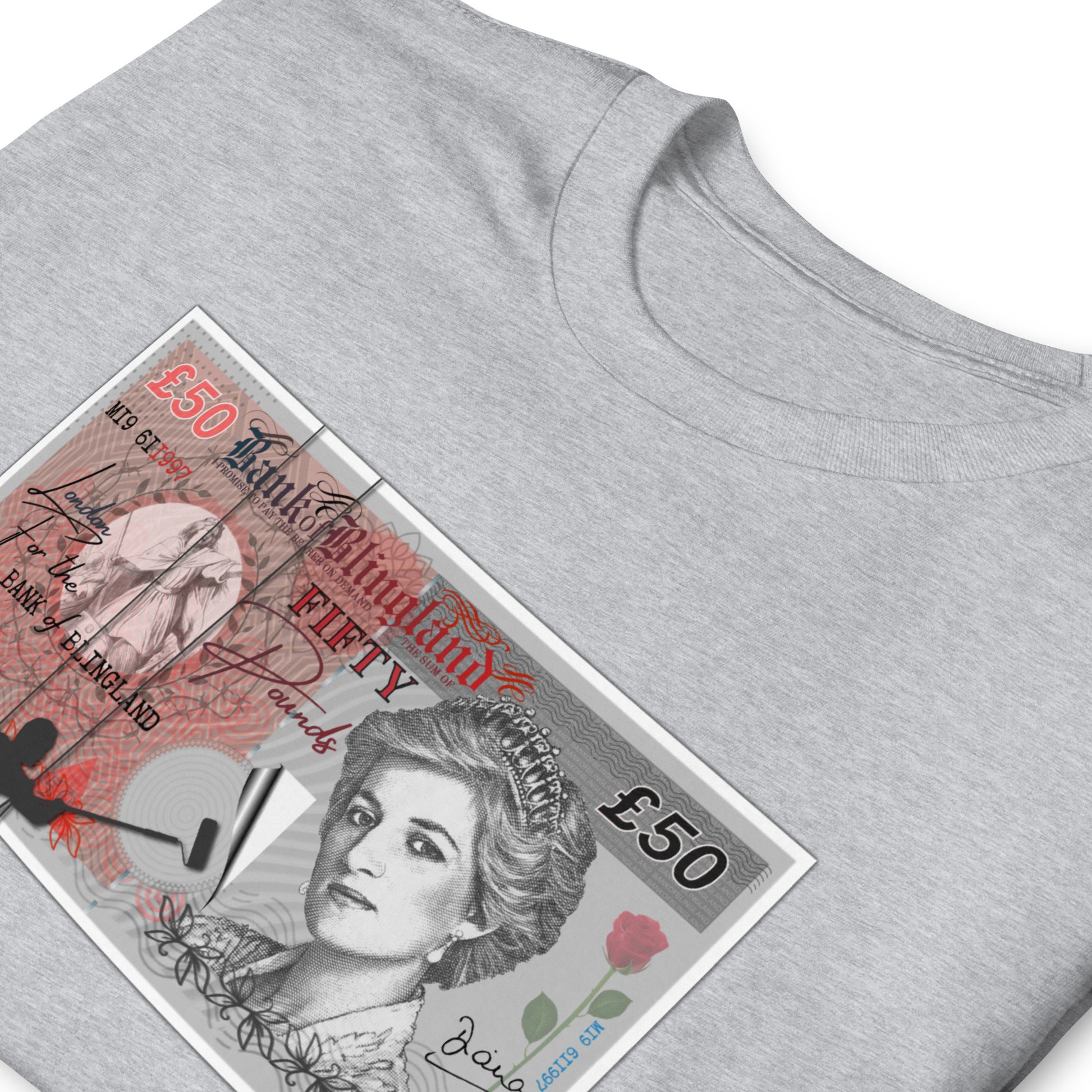 Folded sport grey T-shirt featuring a spoof £50 note with Princess Diana on it, the money is being posted to a wall by a silhouetted man.